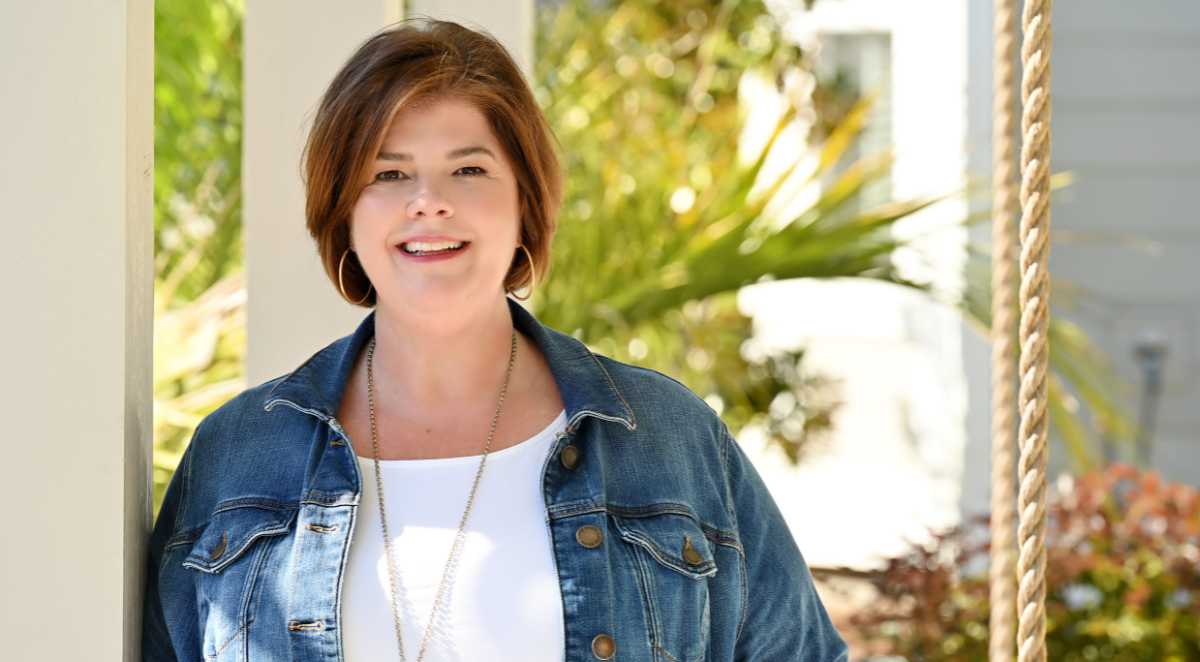 Chrissy Copple, Lowcountry Real Estate Partner, sitting on a southern porch.