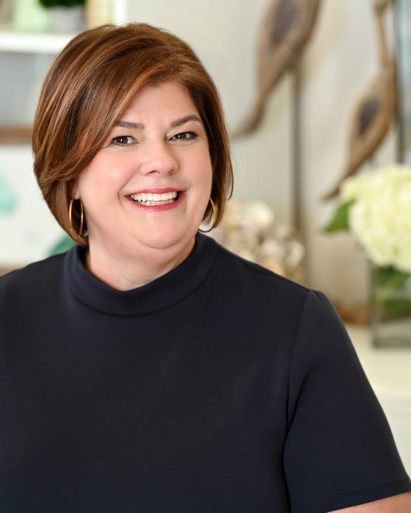 Home. Chrissy Copple, Luxury Real Estate Advisor in Charleston SC, standing in a professional setting.